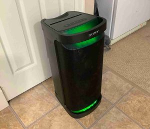 Picture of the left front of the Sony SRS XP700 speaker, showing its party lights glowing green.
